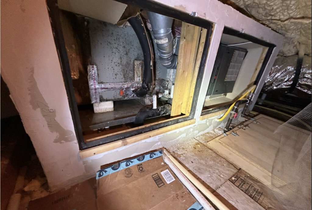 Attic air handler closet opened up, showing dark spots on the unit