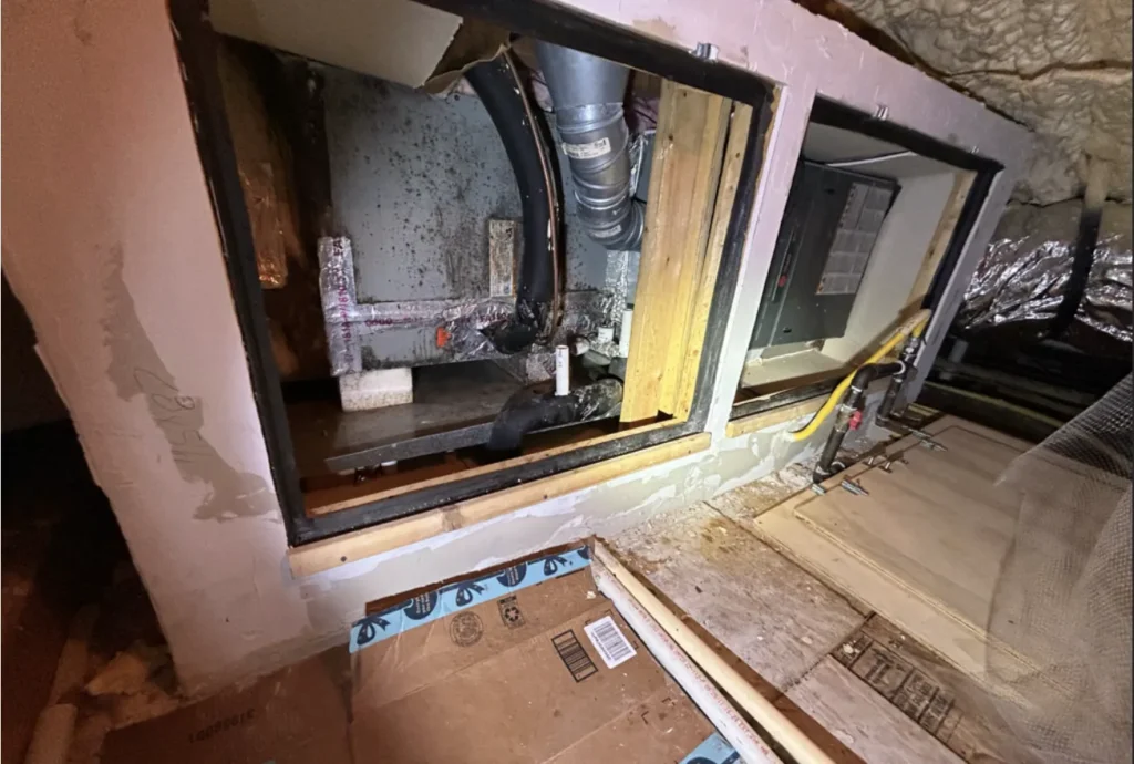 Attic air handler closet opened up, showing dark spots on the unit