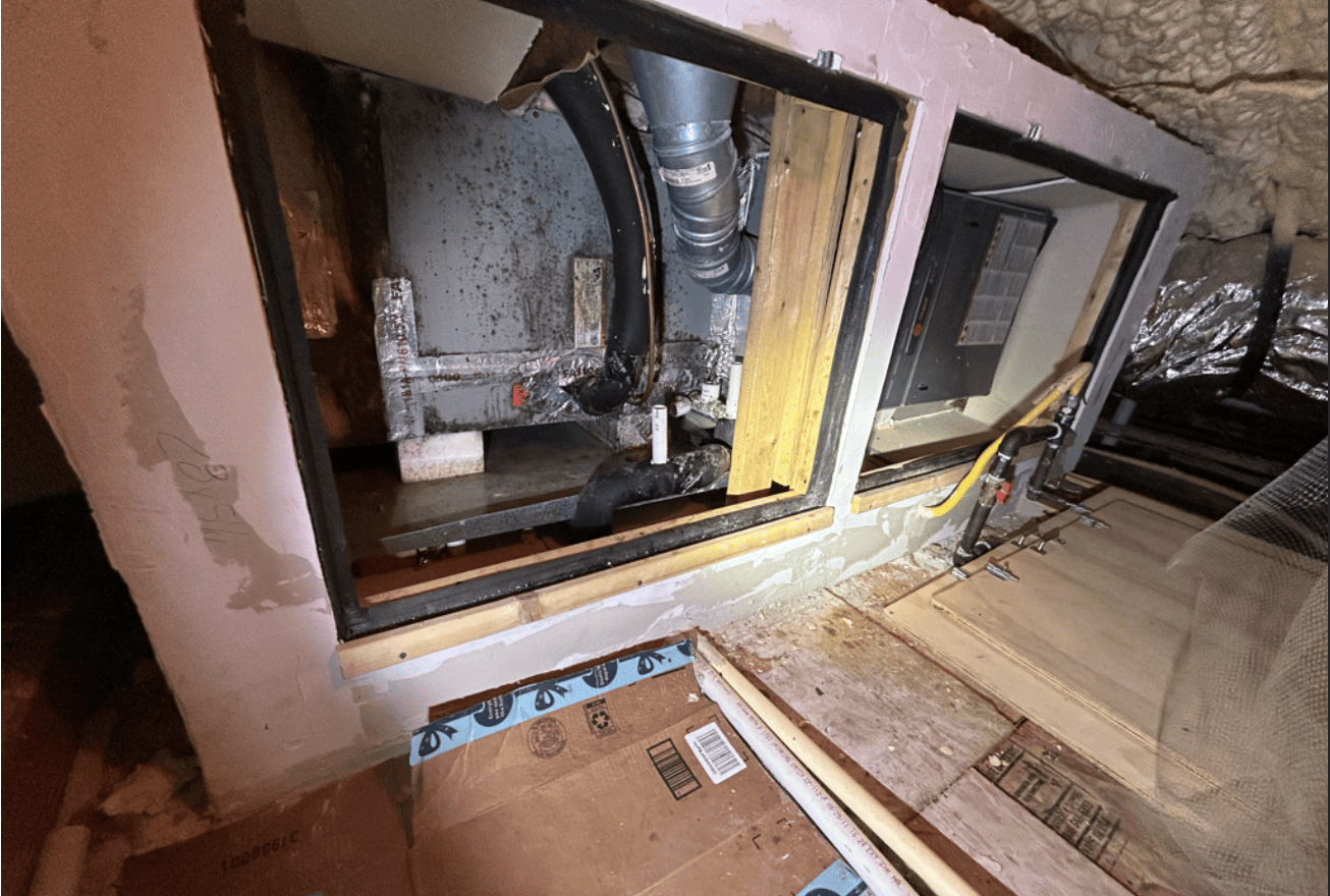Attic air handler closet opened up, showing dark spots on the unit