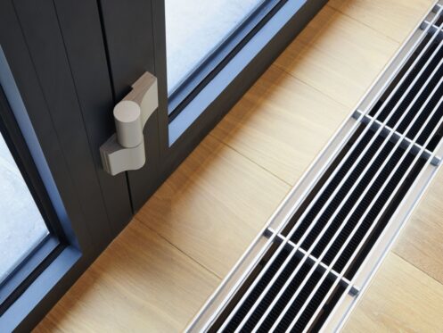 Floor vent with modern design next to a window