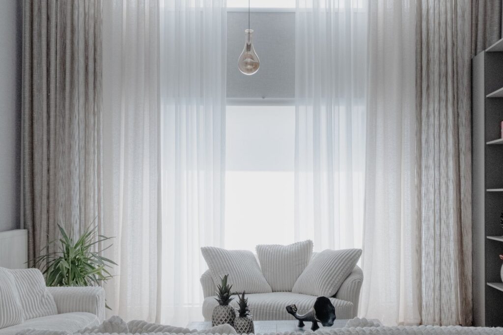 Bright living room with sheer curtains and white furniture