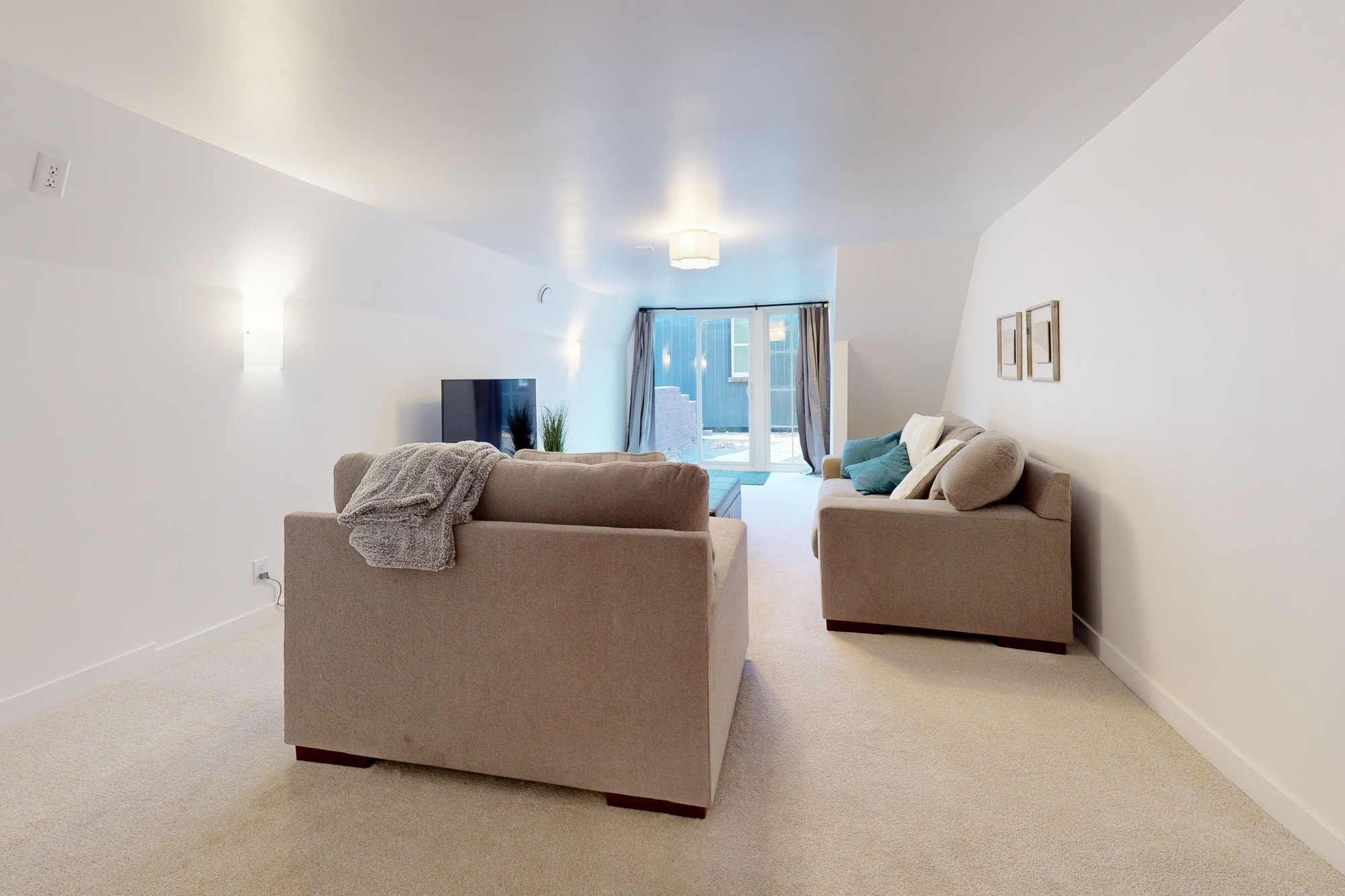 Clean, empty living room with neutral sofas and carpet