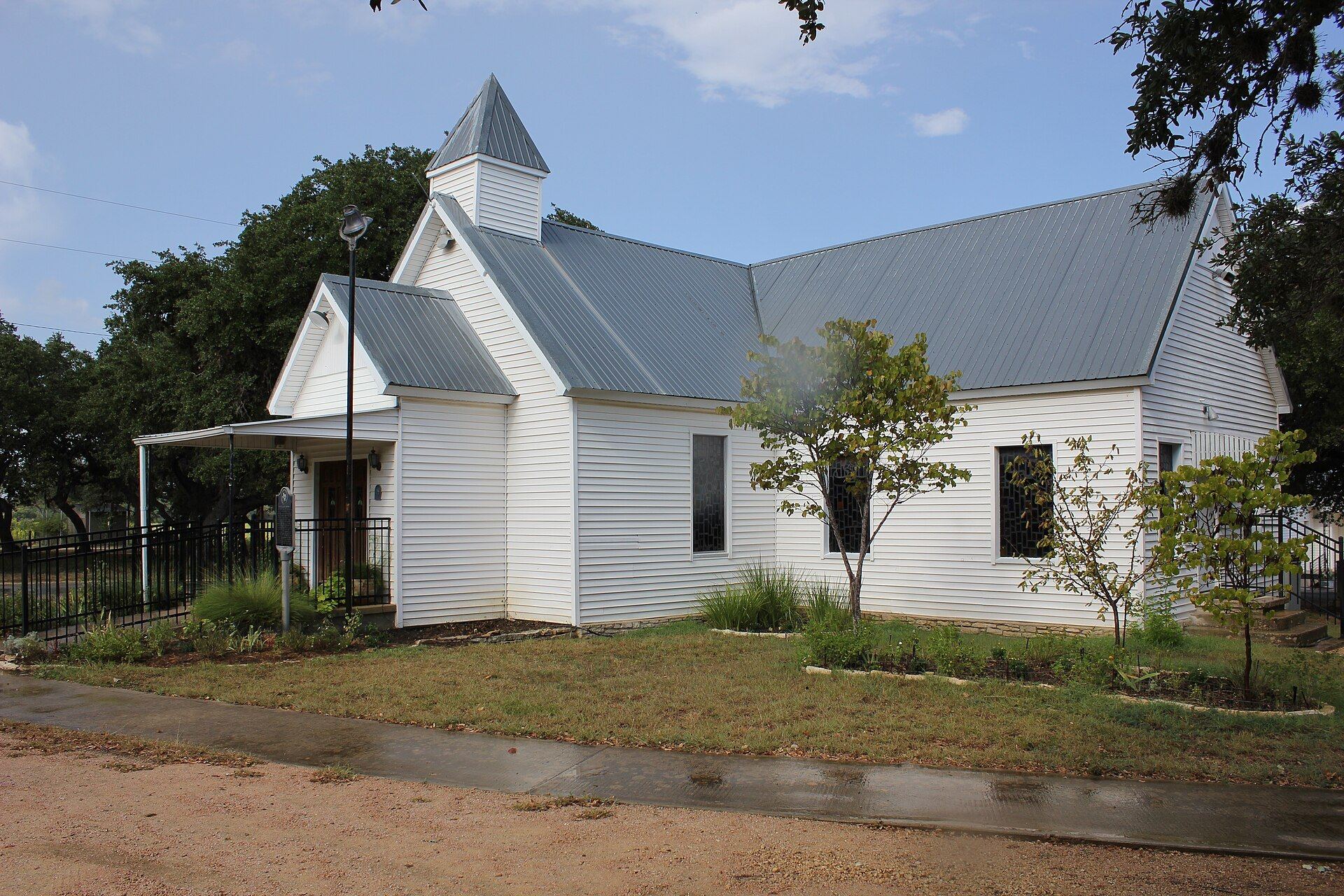 Historic white wooden Driftwood Church among oak trees in Driftwood, Texas