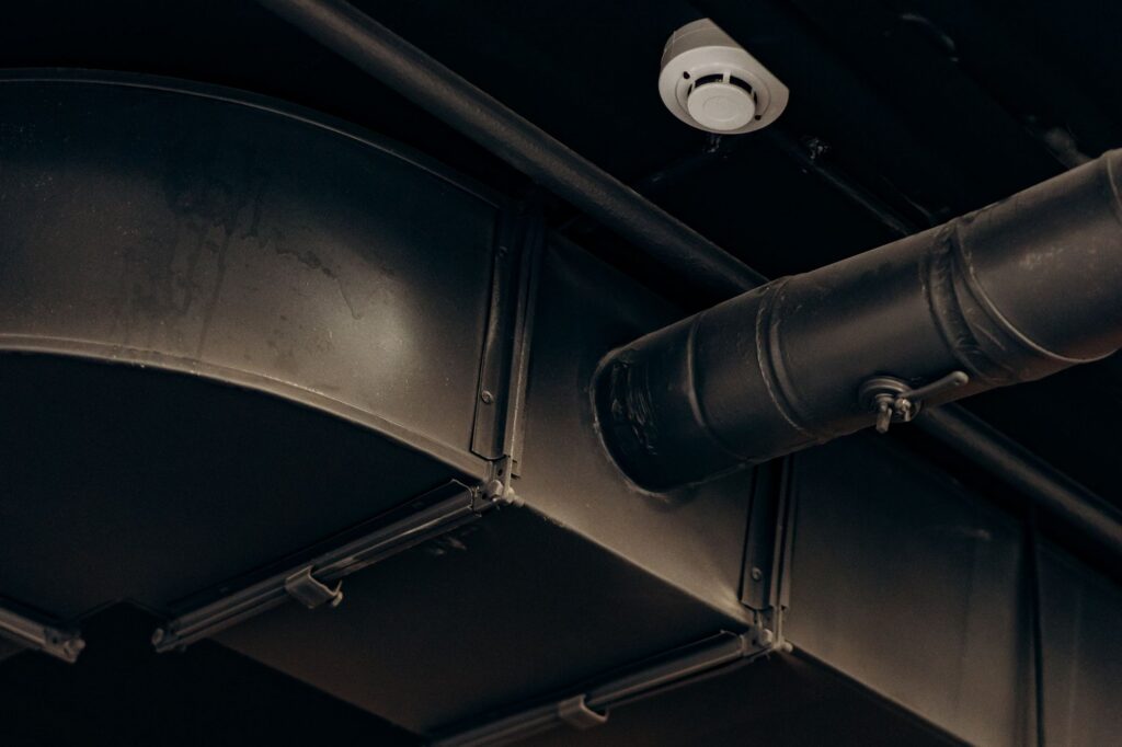 Large rectangular and round air ducts running along a ceiling