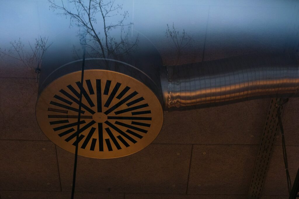 Round metal air vent connected to insulated ductwork