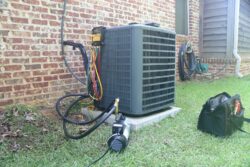 ac unit being repaired next to a brick house