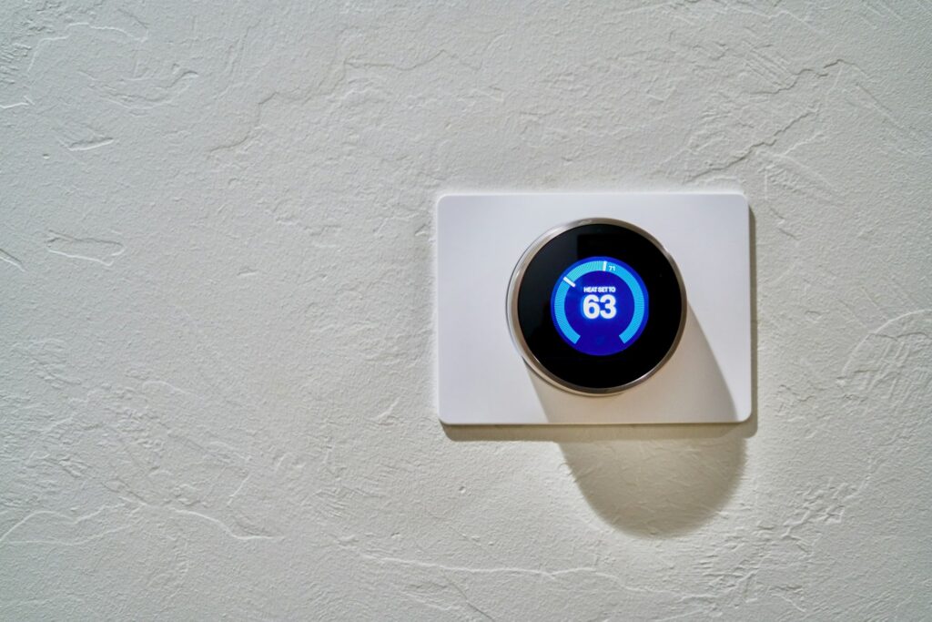 Smart thermostat mounted on a textured white wall
