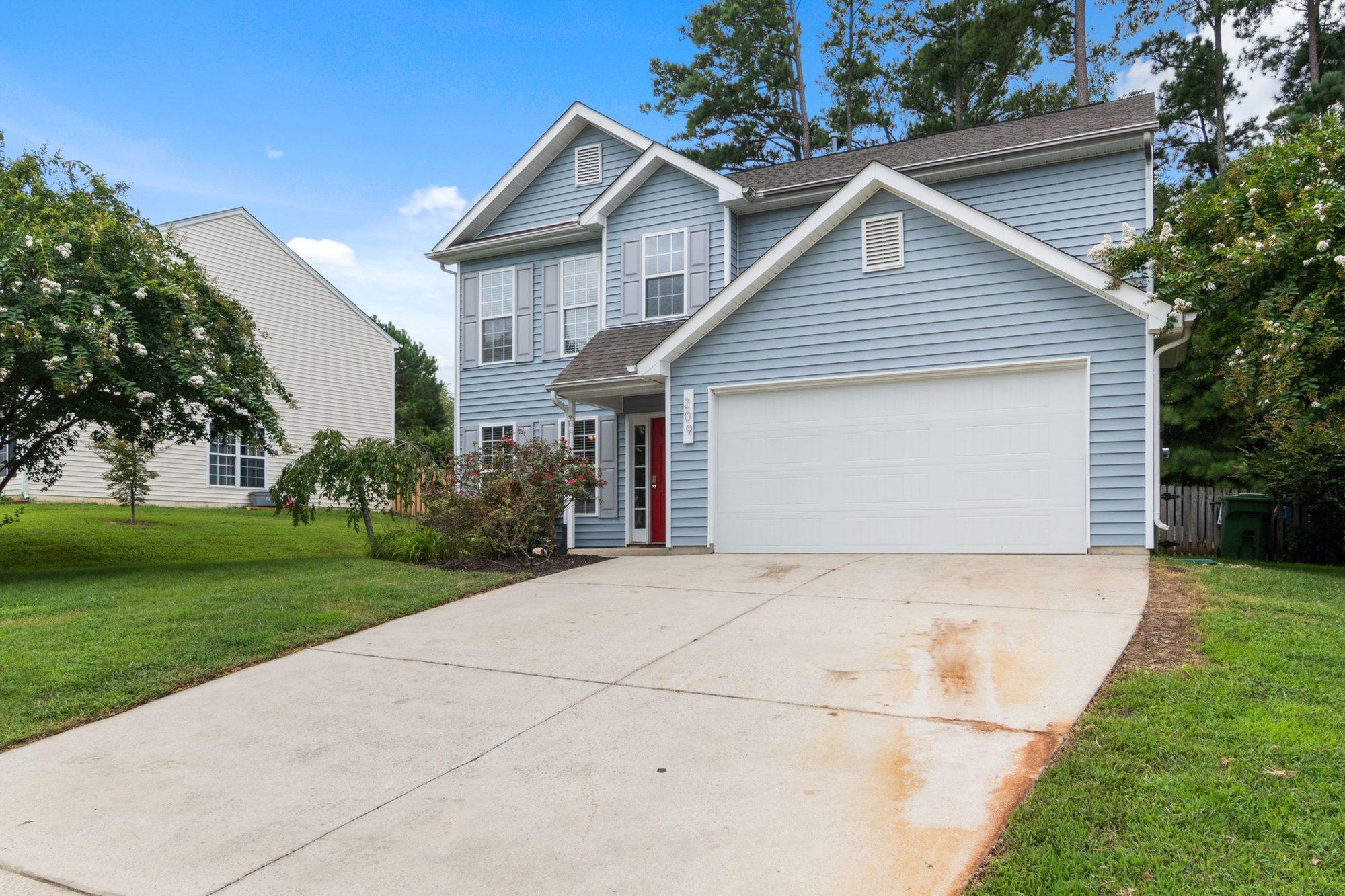 Two-story suburban home with an attached garage and long driveway