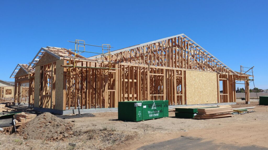 Wood-framed house under construction on a sunny day